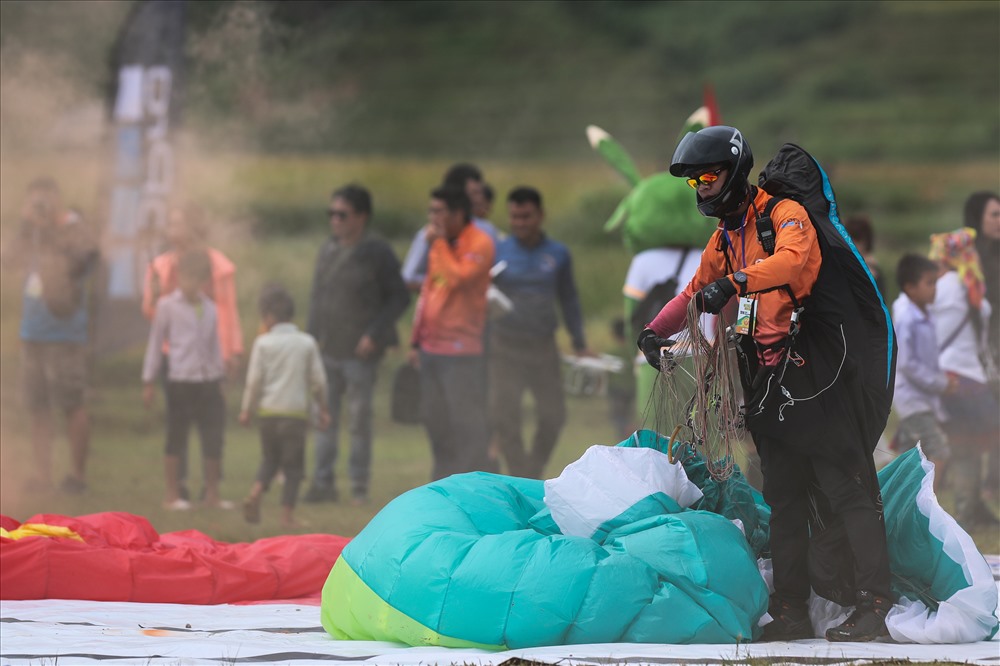 Sáng 21/9, đỉnh đèo Khau Phạ có mưa phùn, sương mù nhưng nhiều cánh dù của các VĐV nhiều kinh nghiệm vẫn có thể đưa du khách lên độ cao hàng trăm mét để bay lượn ngắm cảnh.