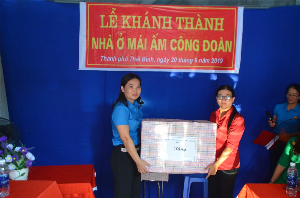 Đồng chí Phí Thị Thanh Huyền – Chủ tịch LĐLĐ Thành phố trao quà chúc mừng chị Mai về nhà mới. Ảnh: B.Mạnh