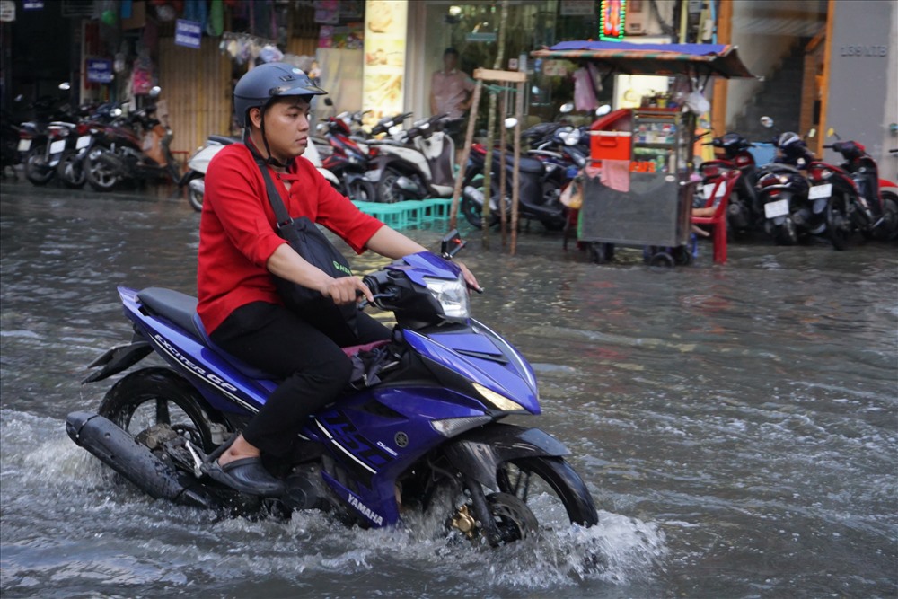 Tuy triều cường chưa đạt đỉnh nhưng người dân đã phải bì bõm trong nước ngập.