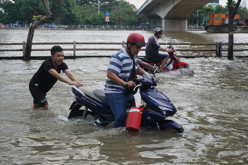 Người dân trên đường Trần Xuân Soạn giúp đỡ người đi đường bi xe chết máy.