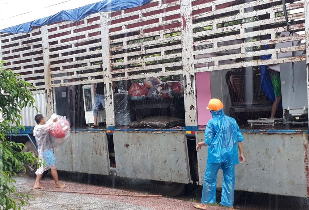 Người dân di chuyển đồ đạc ra khỏi vùng bị ngập nước ở thị trấn Lao Bảo. Ảnh: TH.
