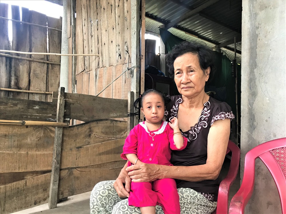 Bà Hà và thiếu nữ “tí hon” Lê Thị Kim Ly (phía sau là căn nhà lụp xụp, dựng tạm - nơi hai bà cháu đang sinh sống). Ảnh: B.T
