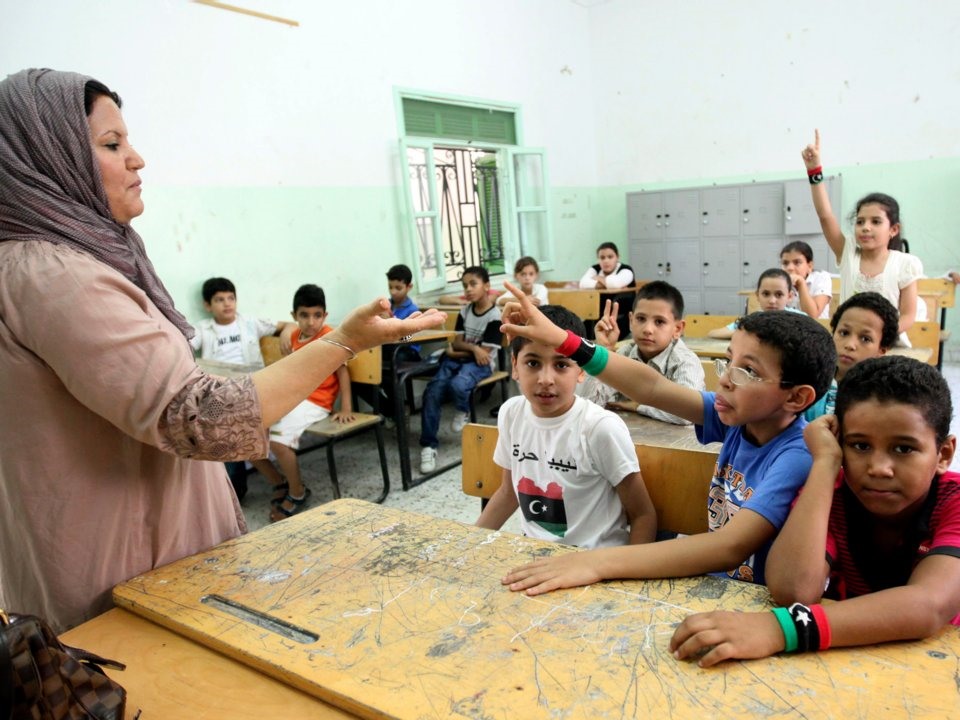 Giáo viên đang trao đổi với học sinh trong một lớp học ở thủ đô Tripoli, Libya trong ngày đầu tiên của năm học mới. Ảnh: Reuters.