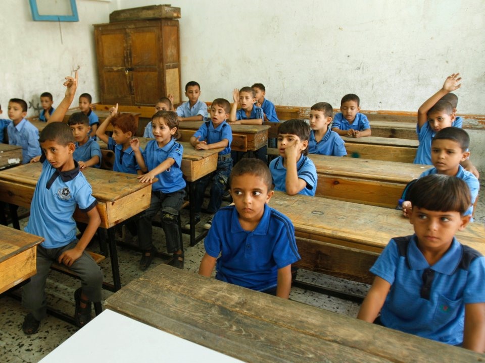 Trẻ em Palestine ngồi trong một lớp học trong ngày khai giảng tại trường al-Shafi'i, thành phố Gaza. Ảnh: Reuters.