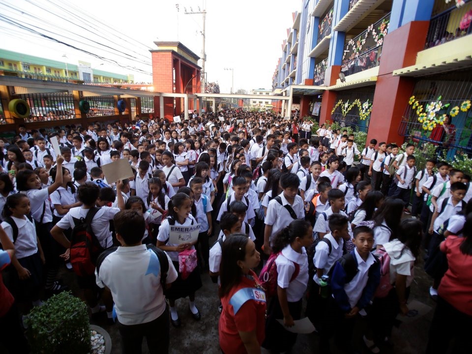 Học sinh Philippines xếp hàng trong ngày đầu tiên đến trường tại trường tiểu học Tổng thống Corazon C. Aquino ở ngoại ô phía bắc Manila. Ảnh: AP.