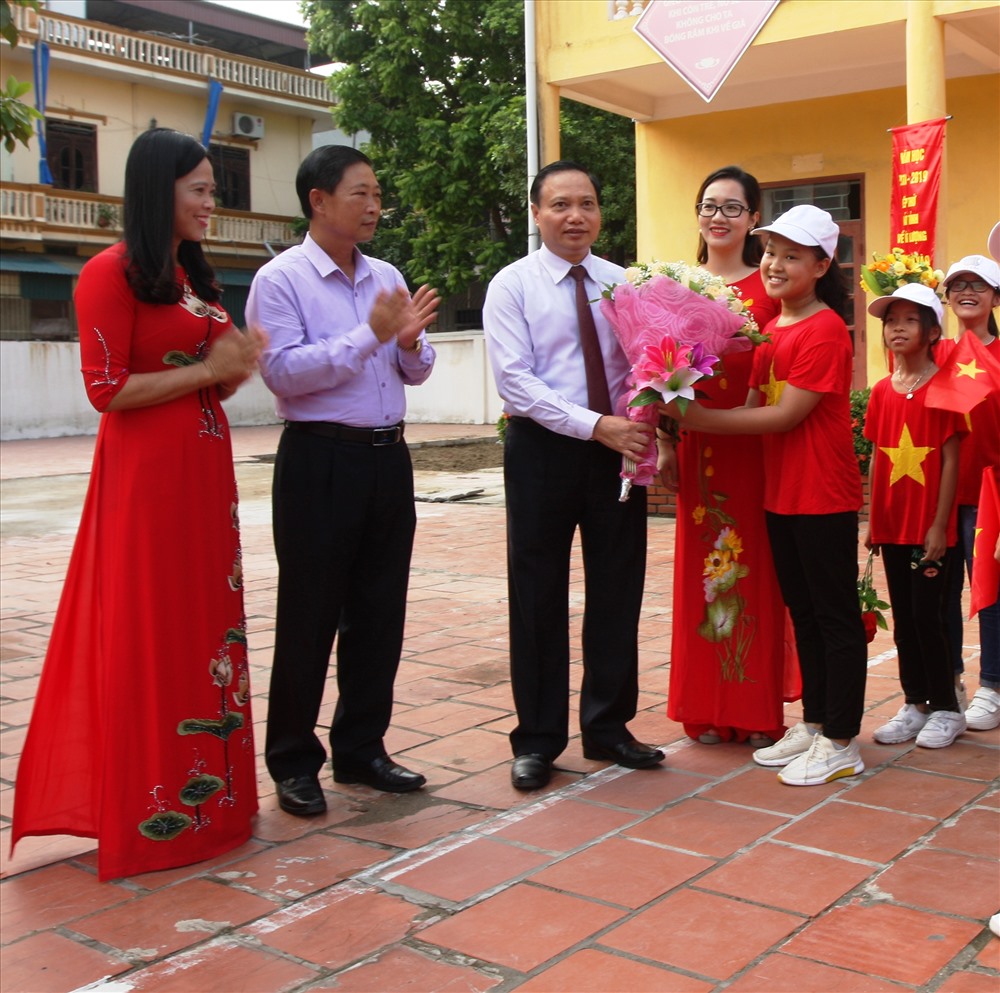 Ông Trần Hồng Quảng, Phó bí thư Thường trực Tỉnh ủy - Chủ tịch HDND tỉnh Ninh Bình tặng hoa và đón các em học sinh đầu khóa vào nhận lớp tại Trường THCS Trương Hán Siêu. Ảnh: NT