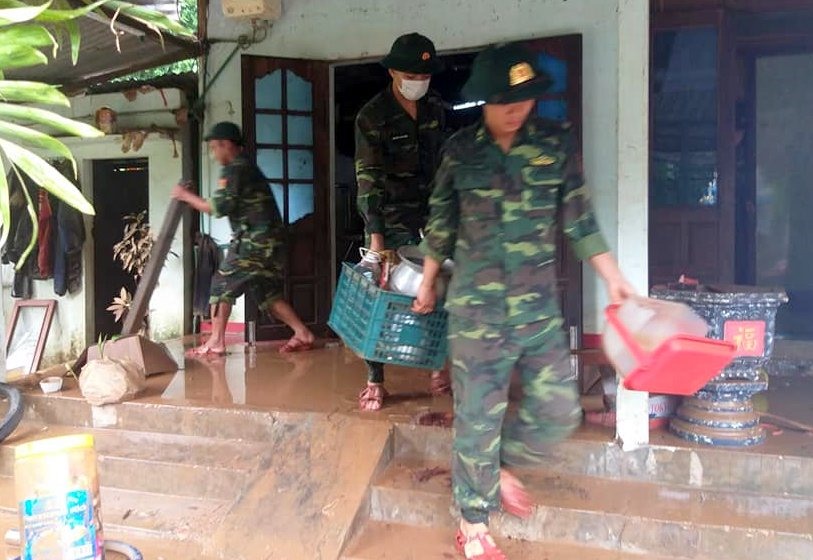 Lực lượng Biên phòng Quảng Trị giúp người dân bị ngập lụt ở thị trấn Lao Bảo dọn dẹp nhà cửa. Ảnh: Quang Thuyên.