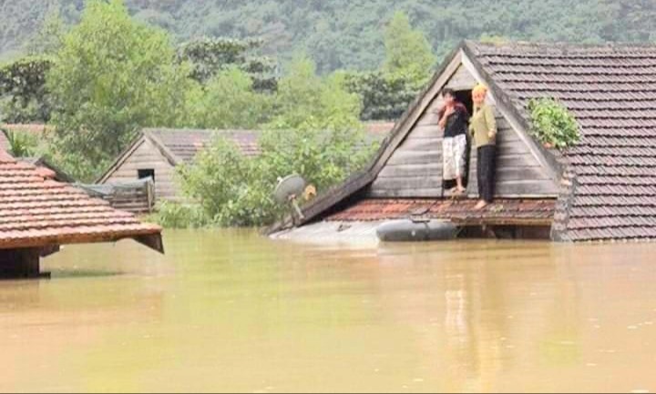 Người dân đứng trên nóc nhà để tránh lũ tại xã Tân Hóa, huyện Minh Hóa. Ảnh: CTV