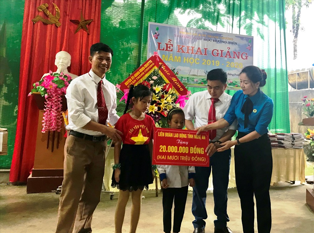 Phó Chủ tịch LĐLĐ tỉnh Nghệ An Nguyễn Thị Thu Nhi (bìa phải) tặng quà cho học sinh huyện Thanh Chương.