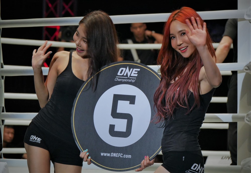 Gương mặt được chú ý nhiều nhất là nữ DJ danh tiếng Lee Jina – người đang giữ danh hiệu ring girl số 1 châu Á năm ngoái. 7 cô gái cầm bảng tại giải One Championship lần này đều đến từ Hàn Quốc. Không chỉ cầm bảng công bố hiệp đấu trong mỗi trận, các cô nàng Ring Girl cũng thường kiêm luôn nhiệm vụ PR cho sự kiện - giải đấu.
