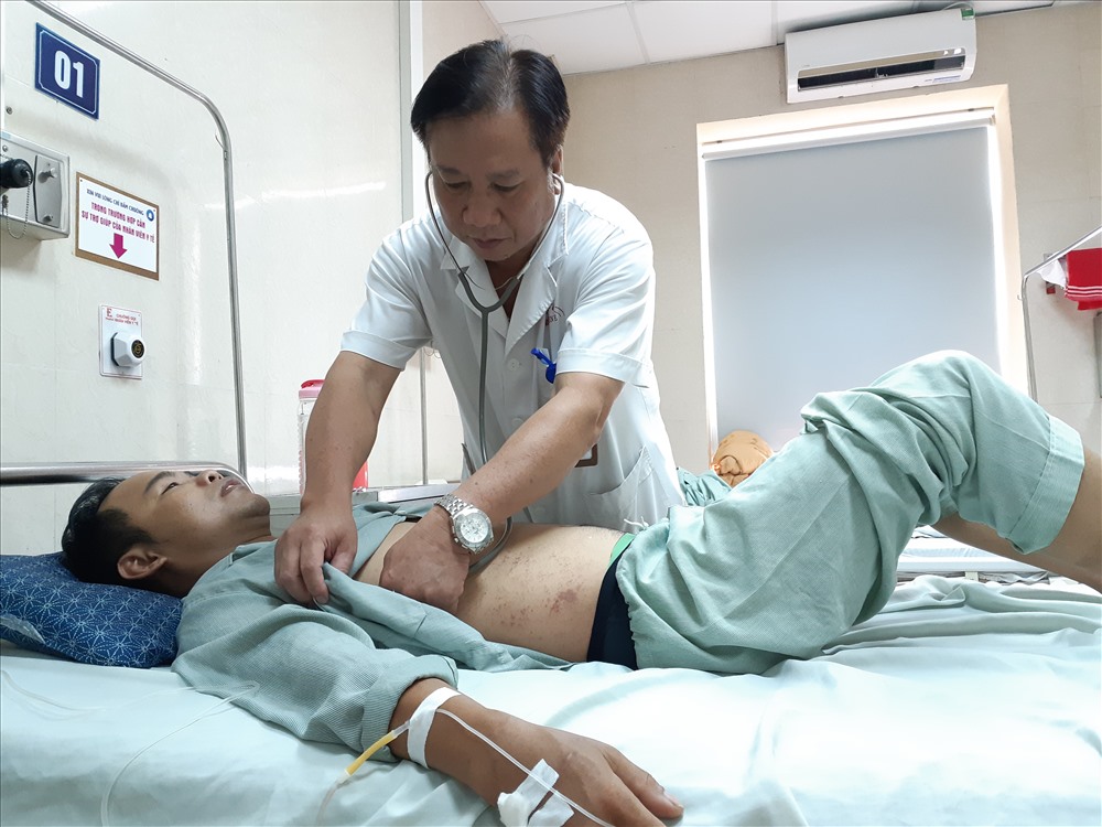 Bác sĩ Nguyễn Văn Hạnh thăm khám cho các bệnh nhân sốt xuất huyết đang điều trị tại bệnh viện E. Ảnh: THÙY LINH