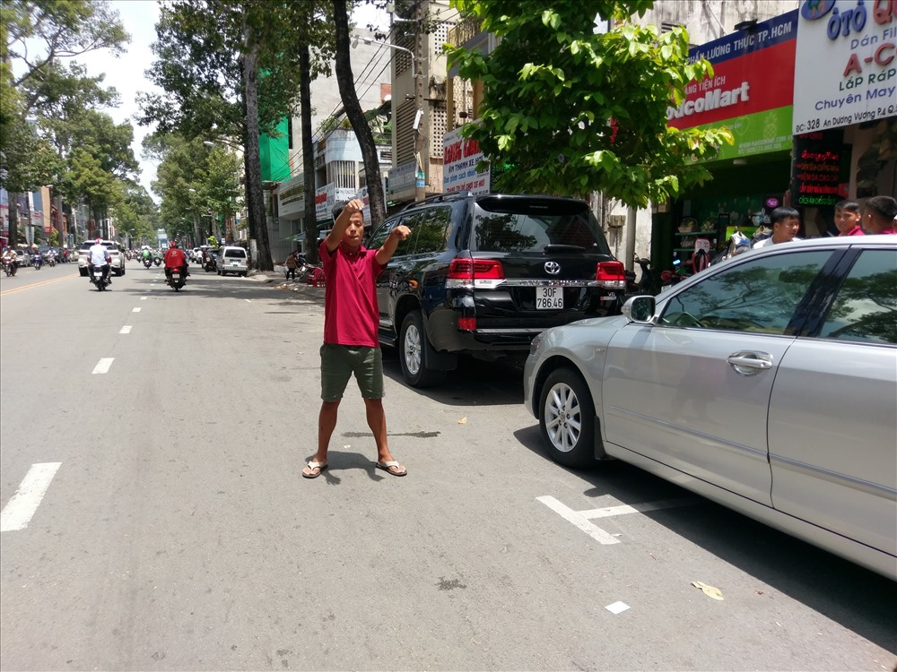 Nhân viên một cửa hàng sửa chữa và buôn bán phụ kiện ôtô trên đường An Dương Vương (Q.5) tràn ra chiếm khu vực đậu xe có thu phí để bắt khách. Ảnh: M.Q