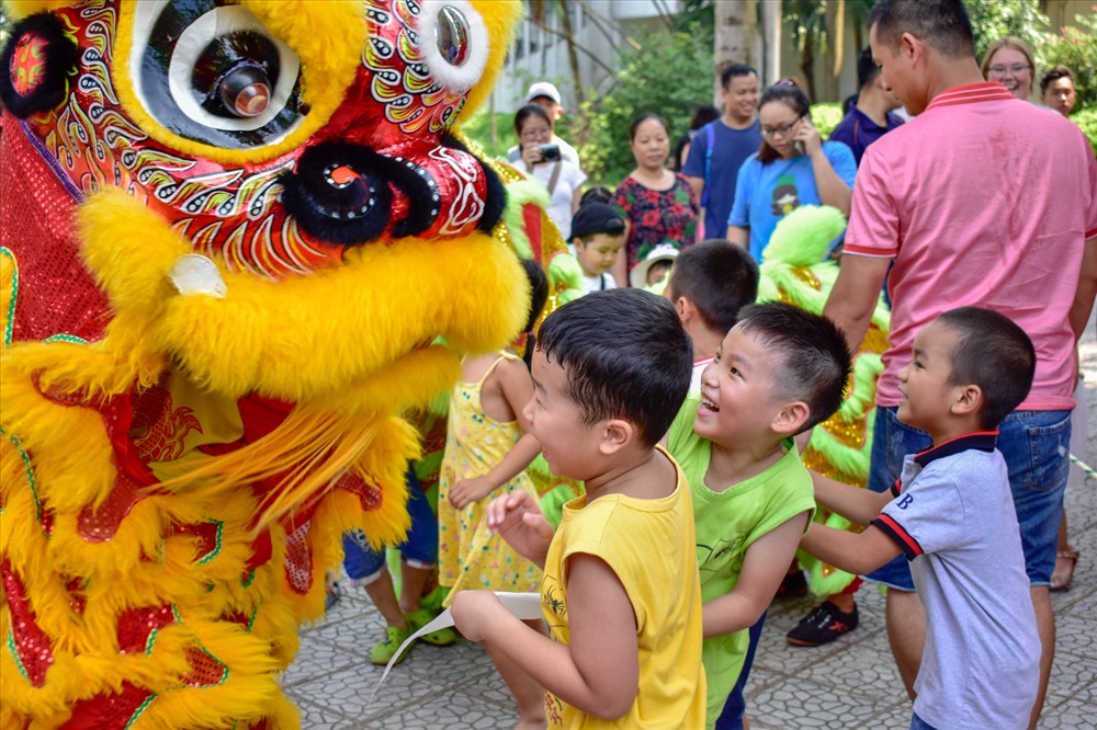 Trẻ em thích thú đùa nghịch với chú lân.