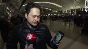 Anh Hassan Shadkhoo, chồng một nạn nhân xấu số trên chuyến bay, đang cho phóng viên xem hình ảnh vợ của mình trên điện thoại. Ảnh: CNN