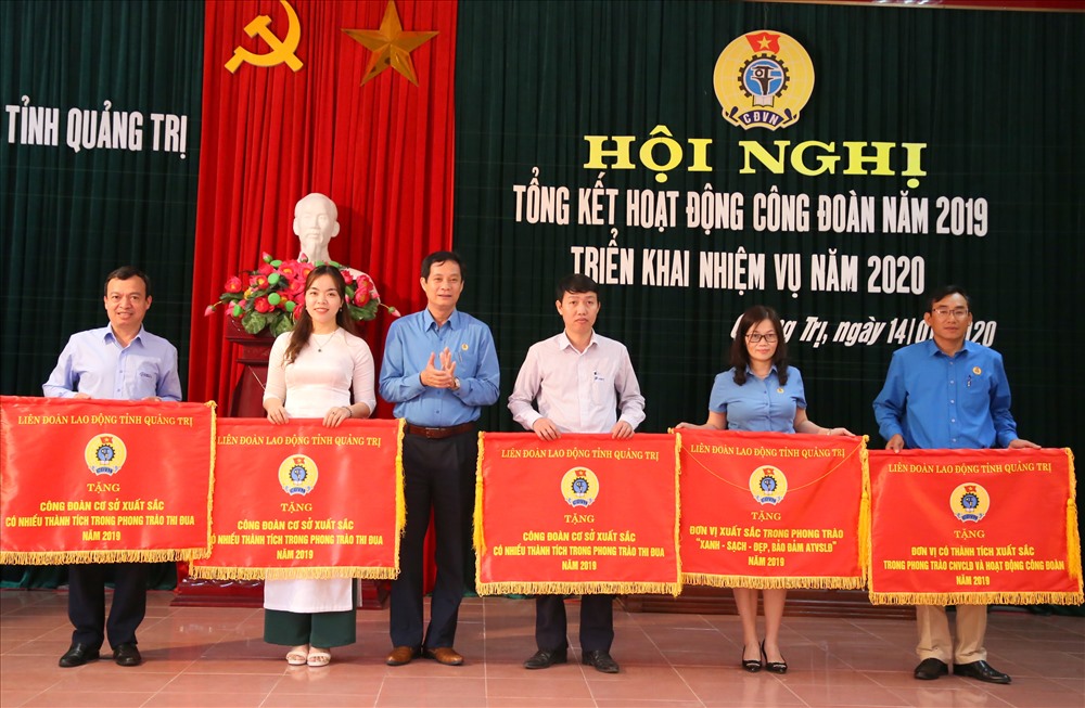 Ông Nguyễn Đăng Bảo - Phó Chủ tịch Thường trực LĐLĐ tỉnh Quảng Trị tặng Cờ thi đua cho 5 tập thể. Ảnh: Hưng Thơ.