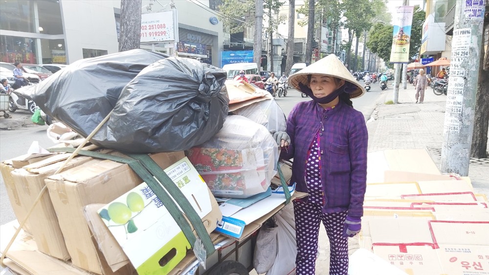 Bà Trần Thị Chín rất vui bên chiếc xe ve chai đầy ấp hàng sau 1 ngày vất vả tìm mua. Ảnh: PV