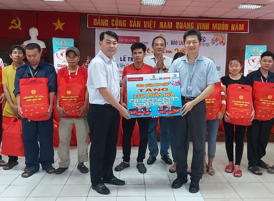 Ông Nguyễn Văn Hải (trái, hàng trên) trao biển tượng trưng 2.375 phần quà cho ông Lũ Khải Nguyên, giám đốc điều hành Công ty PouYuen để tặng cho các CNLĐ có hoàn cảnh khó khăn của công ty. Ảnh Nam Dương