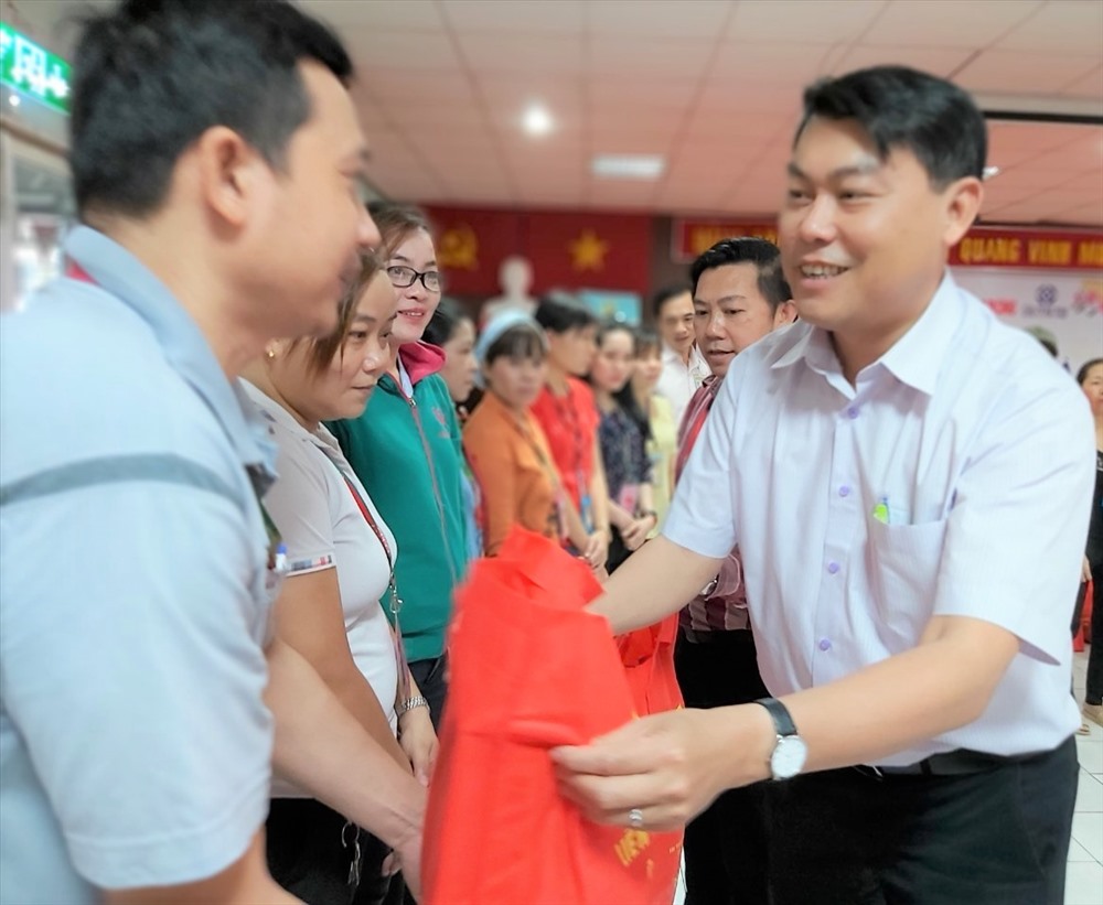 Ông Nguyễn Văn Hải (bên phải), Chủ tịch LĐLĐ Quận Bình Tân, tặng quà cho CNLĐ có hoàn cảnh khó khăn. Ảnh Nam Dương