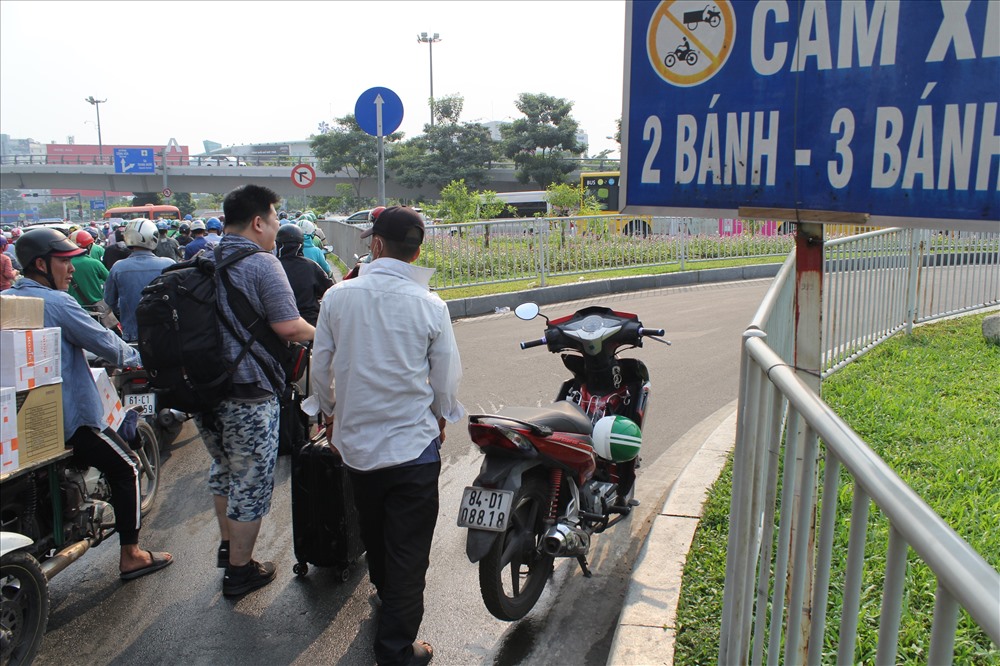Một nam hành khách người nước ngoài vất và cuốc bộ vào sân bay Tân Sơn Nhất vì kẹt xe.