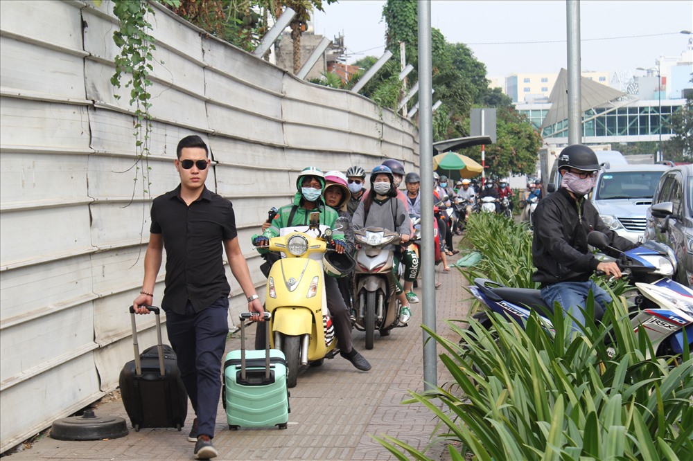 Khu vực trước cổng sân bay, đường Trường Sơn, Bạch Đằng, rất nhiều người phải xuống xe, kéo hành lý chạy bộ vào nhà ga.