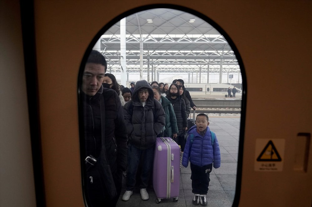 Những hành khách đi tàu tại một nhà ga đường sắt. Ảnh: Reuters