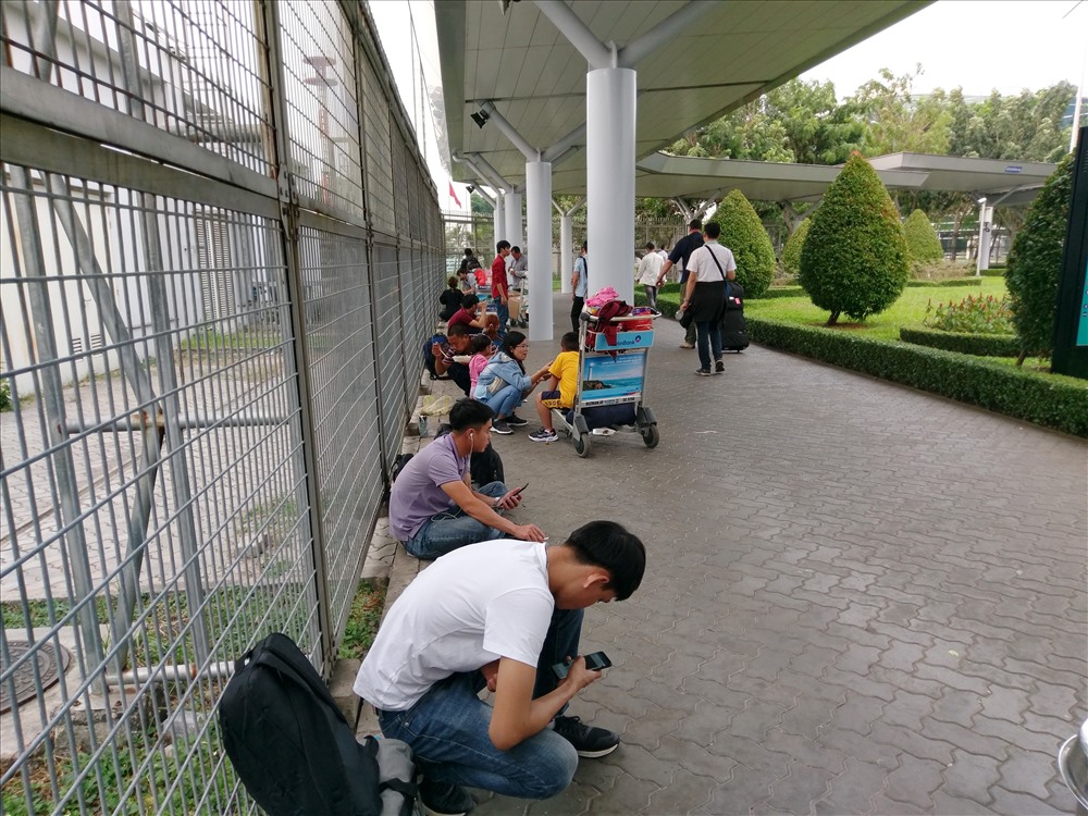 Hành khách nguồi tràn ra cả khu vực hàng rào sân bay Tân Sơn Nhất.