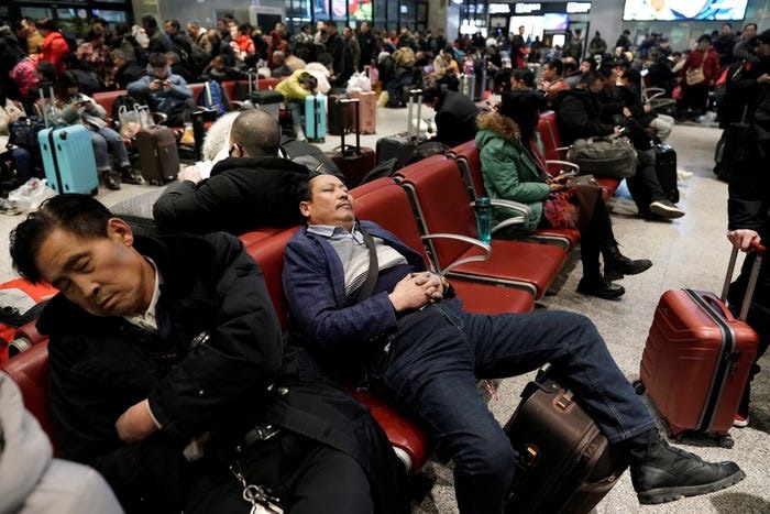 Hành khách mệt mỏi đợi tàu tại một nhà ga ở Bắc Kinh dịp Xuân vận năm 2020. Ảnh: Reuters.