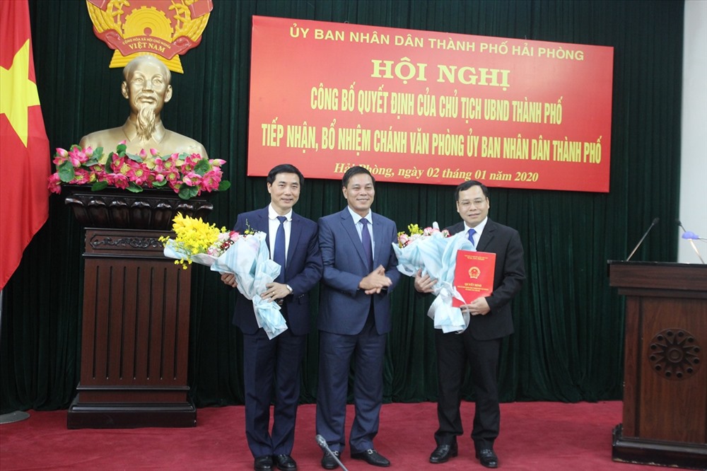 Chủ tịch UBND TP Hải Phòng Nguyễn Văn Tùng (đứng giữa) trao quyết định và tặng hoa cho ông Phạm Hưng Hùng và ông Nguyễn Kim Pha