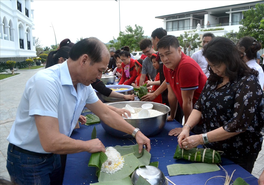 Du khách tự tay gói bánh tét, bánh chưng trong chương trình “Nấu bánh tét - Trở về Tết xưa” do khu du lịch Champa Island tổ chức.