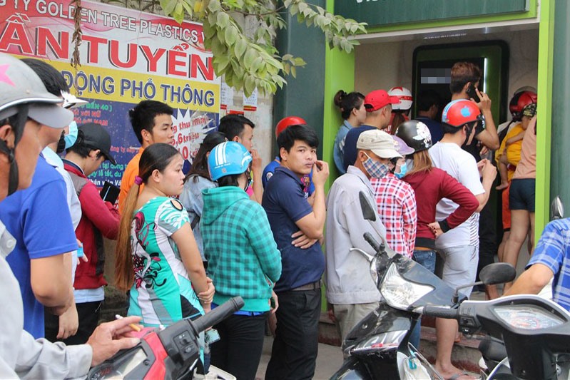 Công nhân chờ rút tiền ở trụ ATM ngay cổng KCN Việt Hương (xã An Tây, thị xã Bến Cát). Ảnh: Đình Trọng
