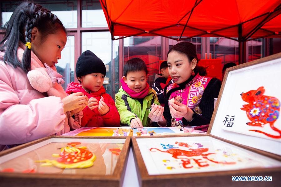 Một nghệ nhận hướng dẫn trẻ em tạo hình bằng bột trong một gian hàng ở liên hoan văn hoá dân gian tổ chức tại Thành phố Nam Kinh, thủ phủ của của tỉnh Giang Tô phía đông Trung Quốc. Ảnh: Xinhua
