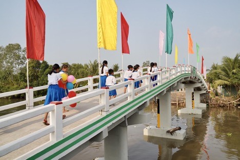 Có chiếc cầu mới, các em học sinh ở xã Phú Quới, huyện Long Hồ, Vĩnh Long rút ngắn được quãng đường đến lớp. (Ảnh: Tất Đạt).