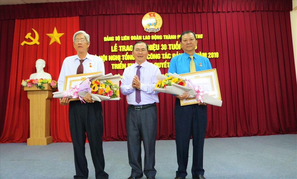 Ông Lê Văn Thành trao huy hiệu 30 năm tuổi Đảng và tặng hoa chúc mừng các đồng chí. Ảnh: Thành Nhân