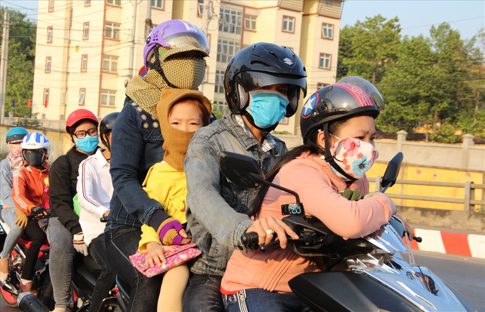Một gia đình 4 người trên xe máy về quê đón Tết. Ảnh: Đình Trọng