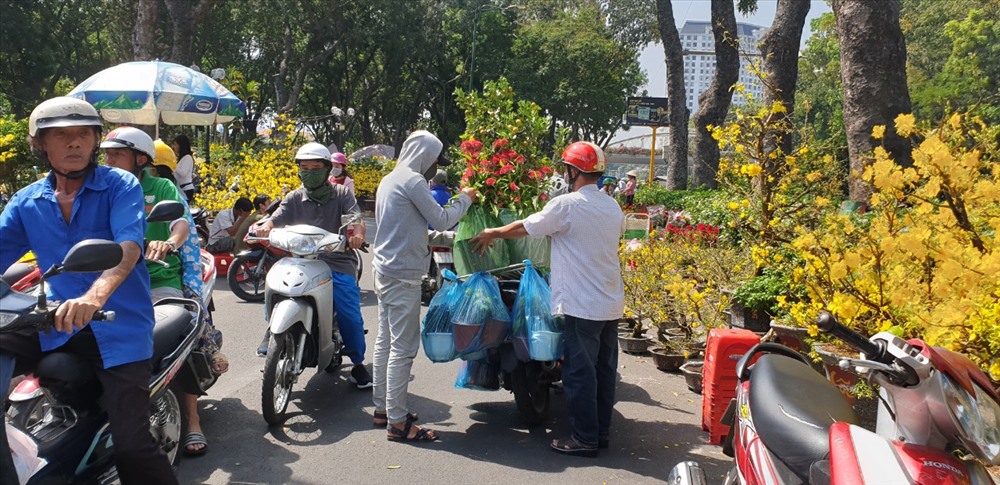Người dân đi mua hoa vào trưa 30 Tết tại công viên Gia Định.