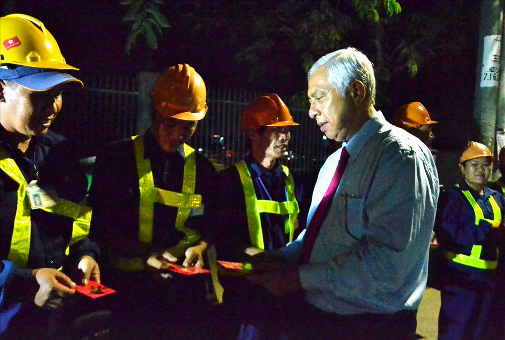 Chủ tịch LĐLĐ An Giang Nguyễn Thiện Phú thăm hỏi, tặng quà cho người lao động trước giờ thu gom rác đêm Giao thừa. Ảnh: Lục Tùng