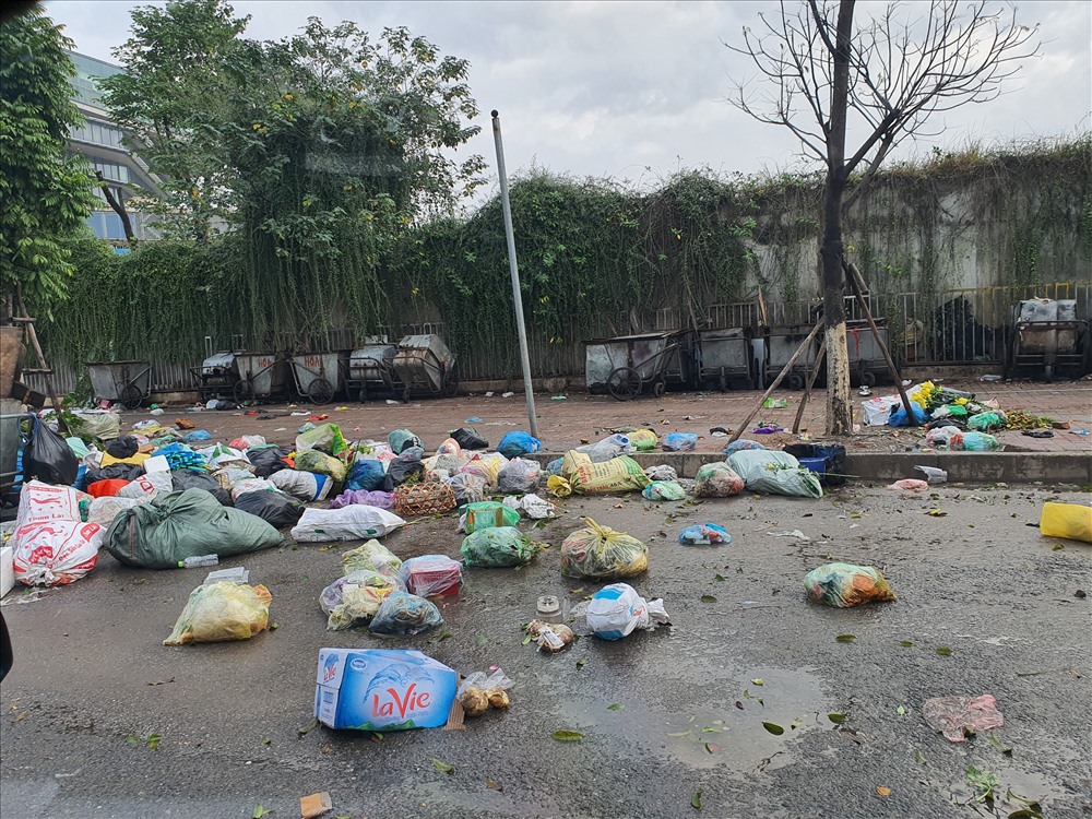 Bãi rác đường Miếu Đầm không được dọn dẹp, tung toé ra ngoài đường.