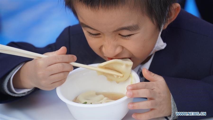 Một đứa trẻ ăn sủi cảo trong dịp Tết Nguyên đán 2020. Ảnh: Xinhua