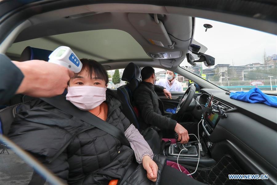 1 nhân viên kiểm tra thân nhiệt của hành khách tại lối ra đường cao tốc ở huyện tự trị Ngọc Bình, phía tây nam tỉnh Quý Châu của Trung Quốc, ngày 26.1. Ảnh: Xinhua