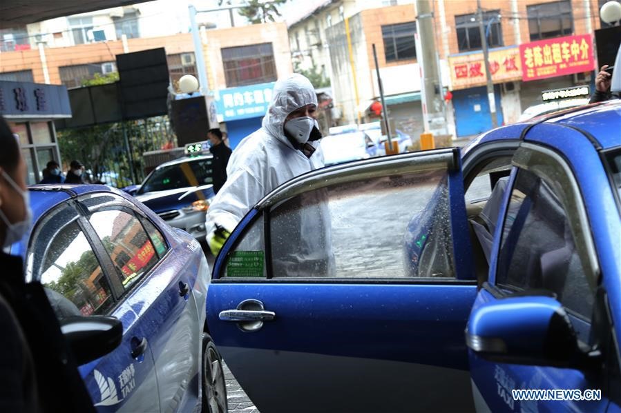 1 nhân viên đang khử trùng một chiếc taxi tại điểm dịch vụ ở Vô Tích, phía đông tỉnh Giang Tô, Trung Quốc, ngày 26.1. Ảnh: Xinhua