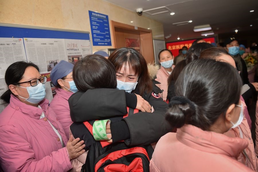 Một thành viên nhóm y tế (đeo ba lô màu đỏ) ôm một đồng nghiệp tại Bệnh viện Bắc Kinh ở Bắc Kinh, Trung Quốc hôm 26.12. Nhóm nhân viên y tế gồm 121 thành viên do Ủy ban Y tế Quốc gia Trung Quốc tổ chức, rời Bắc Kinh tới Vũ Hán chiều 26.1 nhằm hỗ trợ khống chế virus corona. Ảnh: Tân Hoa Xã.