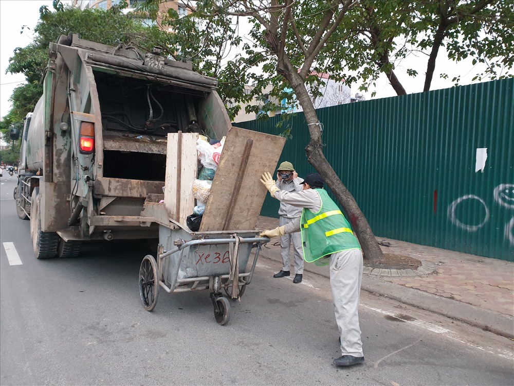 Theo anh Nam, anh bắt đầu ca làm việc từ 16h đến 0h sáng. Vì lượng rác chủ yếu là rác thải sinh hoạt nên rất nặng và khó di chuyển. Tuy nhiên, guồng quay chỉ thực sự bắt đầu sau hôm mồng 5 và kéo dài đến tháng giêng vì đào quất, rác thải sinh hoạt lại tiếp tụp phải thu gom trong những ngày sau Tết. Ảnh: Tùng Giang.