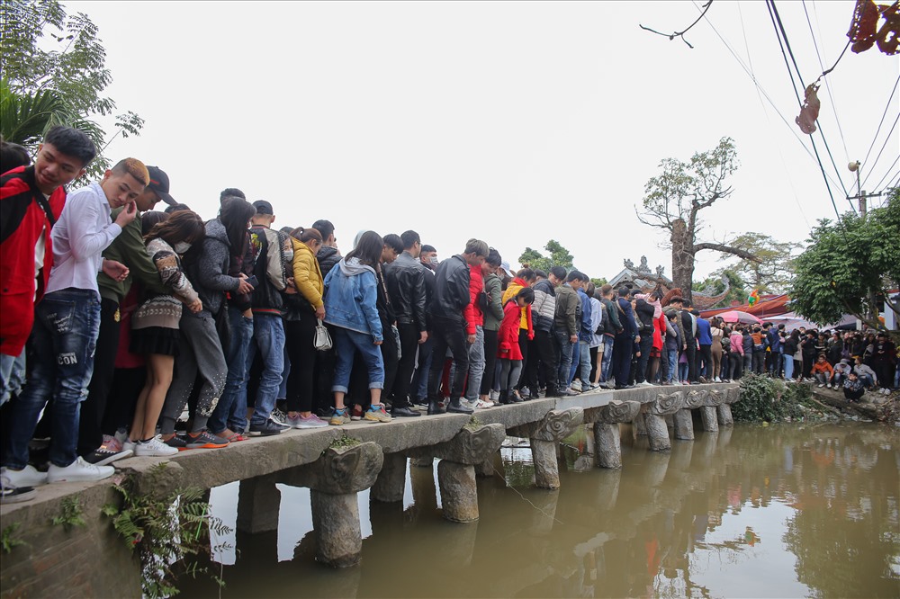 Lối vào duy nhất của ngôi chùa phải qua một cây cầu đá bắc ngang qua dòng sông Nguyệt Đức. Cây cầu đá vững chắc gồm 9 nhịp đầu rồng, đã hơn 200 năm tuổi cõng trên lưng hàng ngàn lượt du khách chen chúc nhau qua lại mỗi ngày vào dịp đầu xuân.