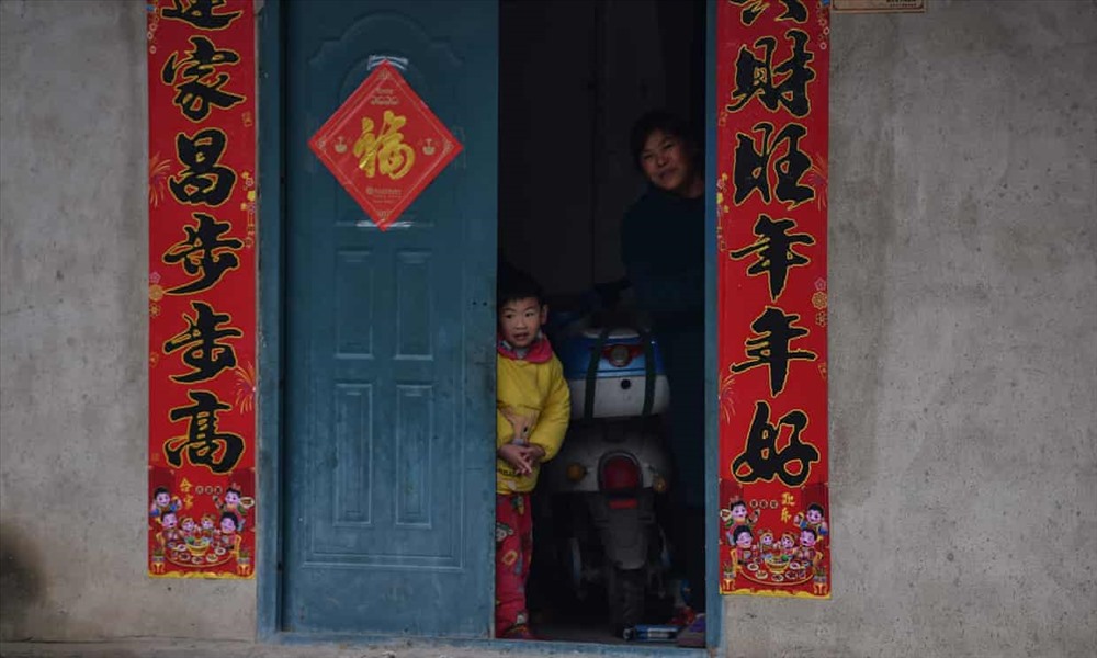 Một gia đình đang nhìn ra khỏi nhà tại khu phố ở ngoại ô Vũ Hán - thành phố có dịch bệnh do virus corona bùng phát ở Trung Quốc. Ảnh: AFP/Getty.