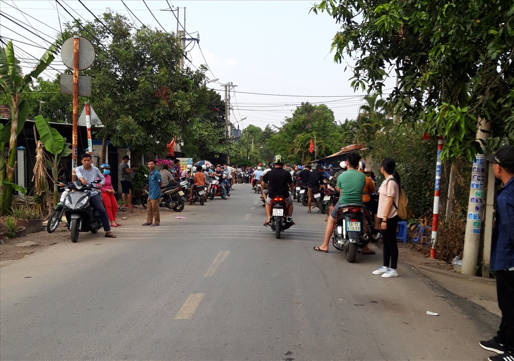 Người dân tụ tập theo dõi cảnh sát vây bắt nghi can ở đường Trung An, xã Trung An, huyện Củ Chi, TP.HCM. Ảnh: AX