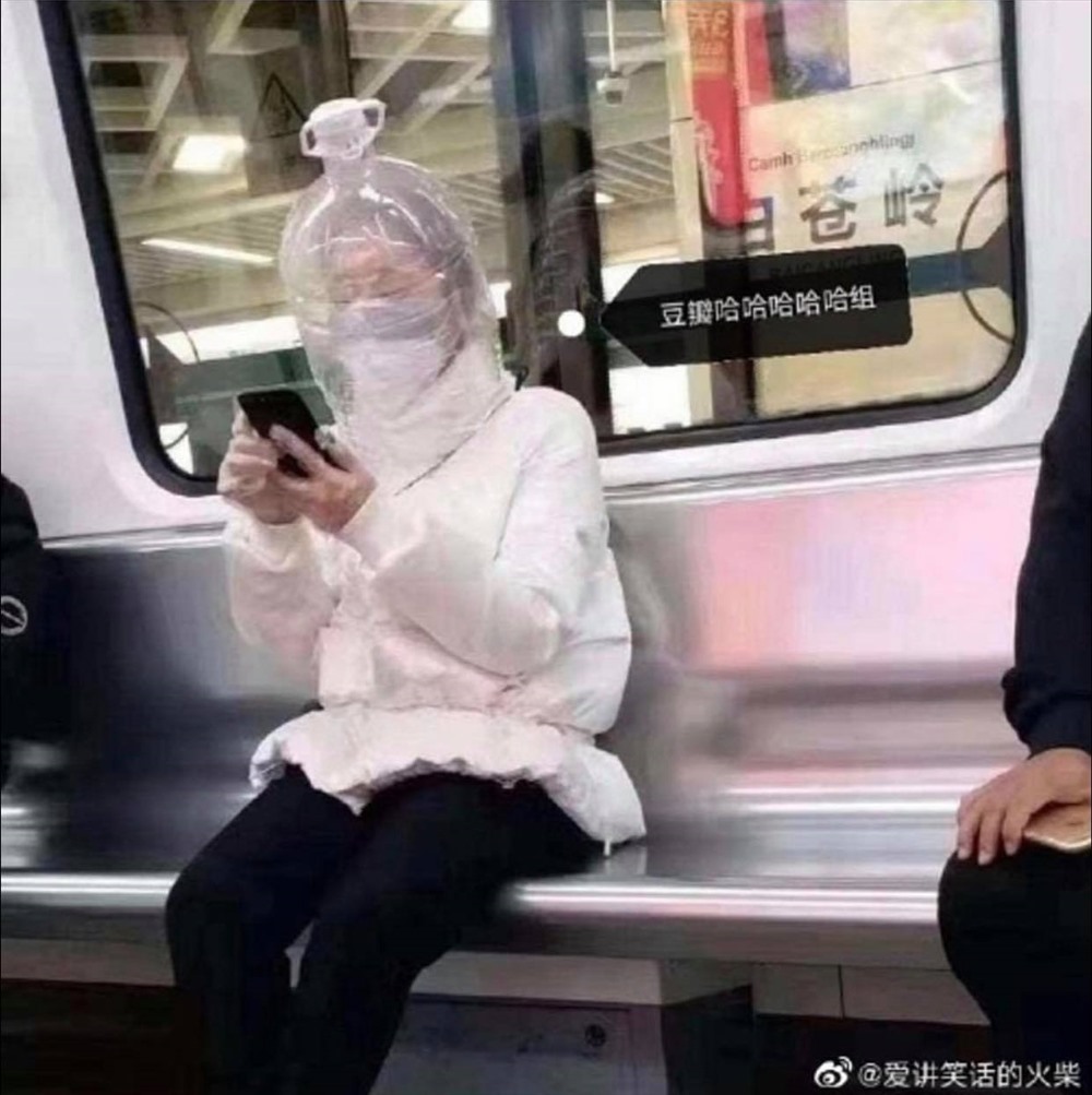 Tại ga tàu điện ngầm, đeo găng tay nilon, khẩu trang, chụp bình nhựa, ung dung ngồi xem điện thoại. Ảnh: Dailymail