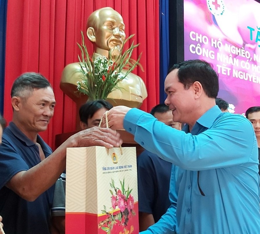 Đồng chí Nguyễn Đình Khang (bên phải) tặng quà của Tổng LĐLĐVN cho các CN có hoàn cảnh khó khăn. Ảnh Nam Dương