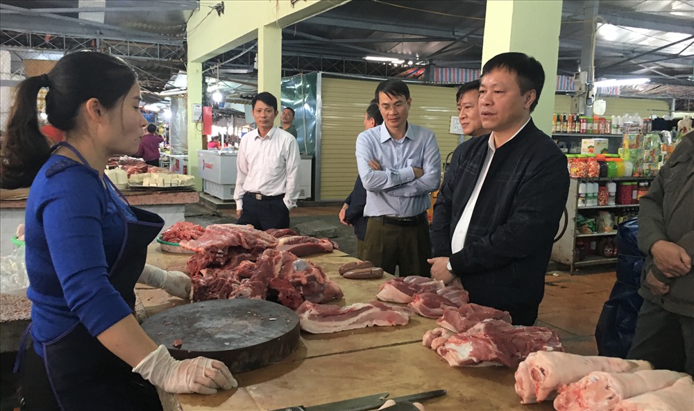 Đoàn khảo sát mặt hàng thịt lợn tại chợ trung tâm Móng Cái và lắng nghe chia sẻ của các tiểu thương trong chợ.