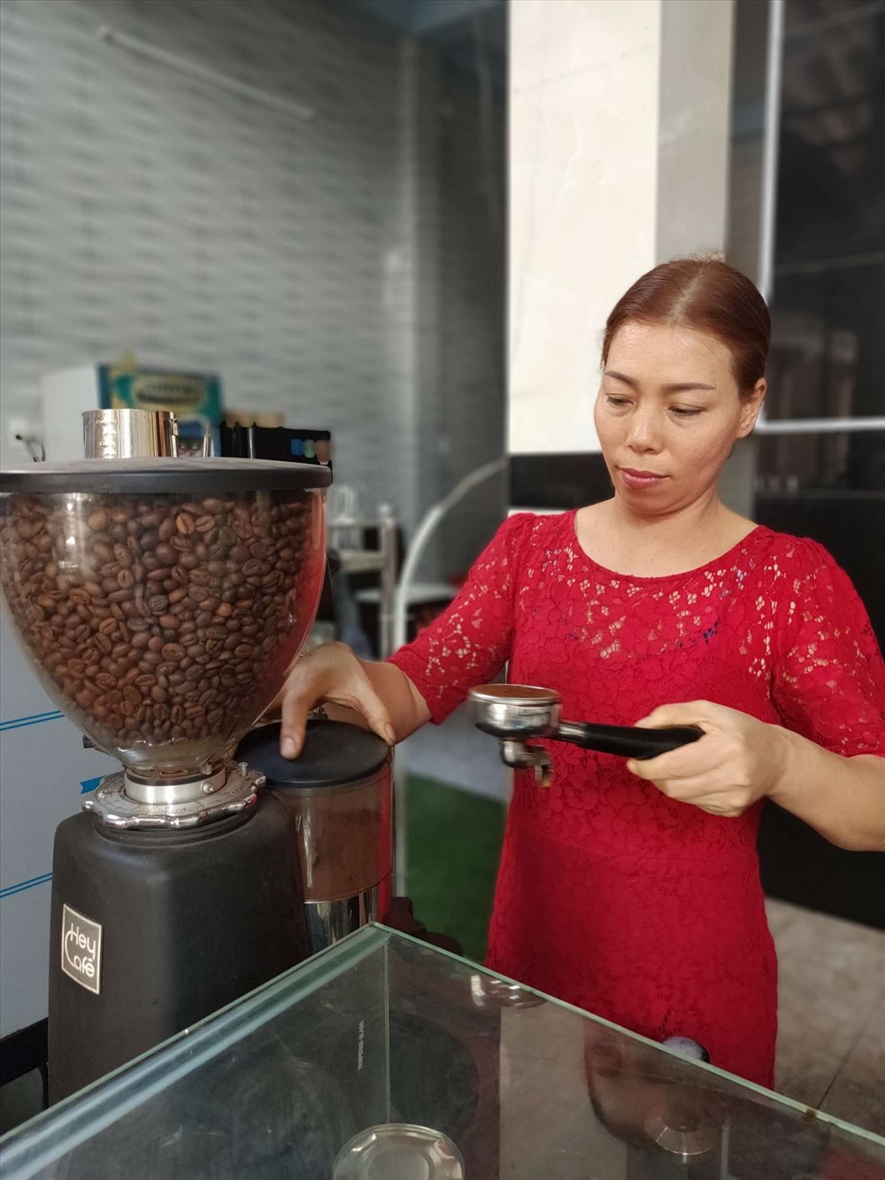 Bà Hà Thị Mai tất bật với việc pha chế cà phê, thu ngân trong những ngày cận Tết Nguyên đán. Ảnh: Nguyễn Đăng.