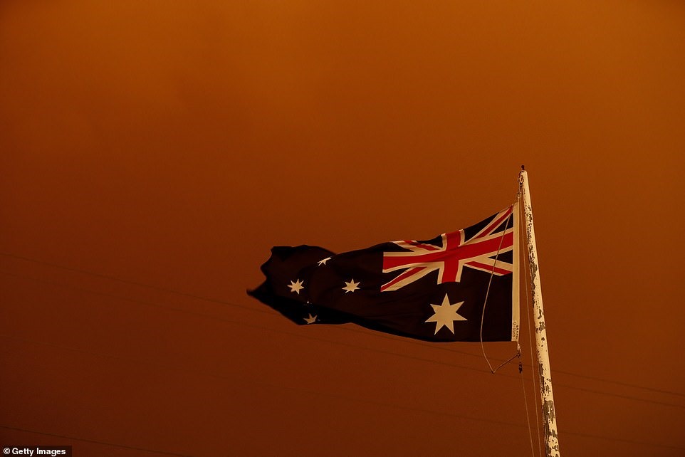 Lá cờ Australia bay trong gió trên nền trời đỏ rực ở thị trấn Bruthenland, bang Victoria.